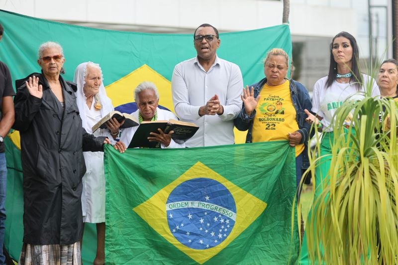Apoiadores de Jair Bolsonaro posam ao lado de bandeira nacional, em frente ao Hospital DF Star, em Brasília.