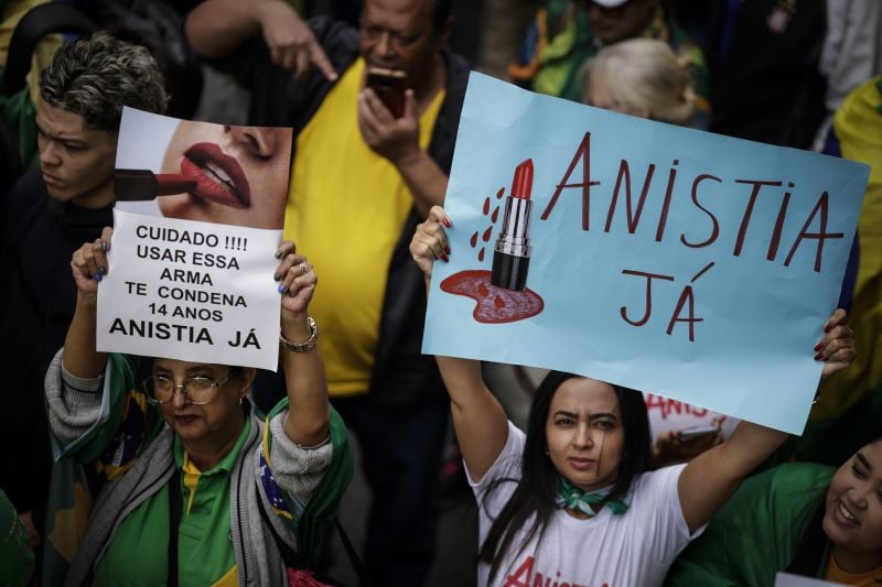 Mulheres seguram cartazes em manifestação pró-anistia em São Paulo.