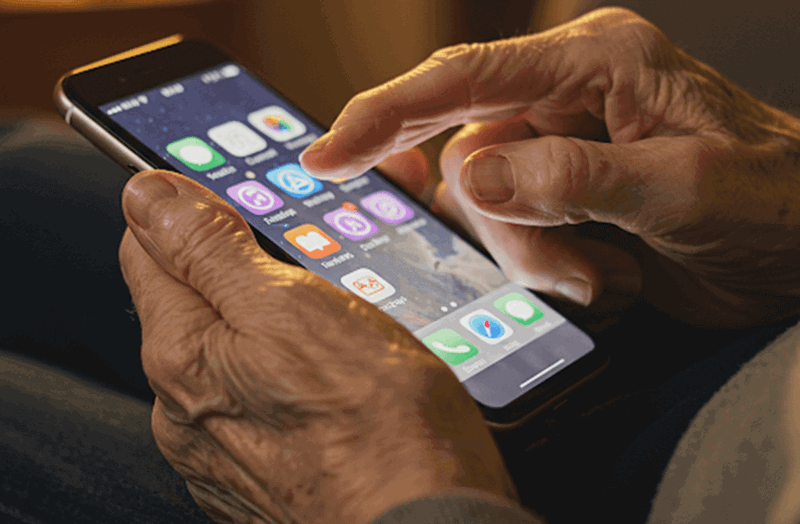 Idoso usa o celular.
