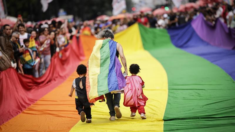 Participantes caminham sobre bandeira LGBTQIA+ durante a Parada Gay em São Paulo no último domingo.