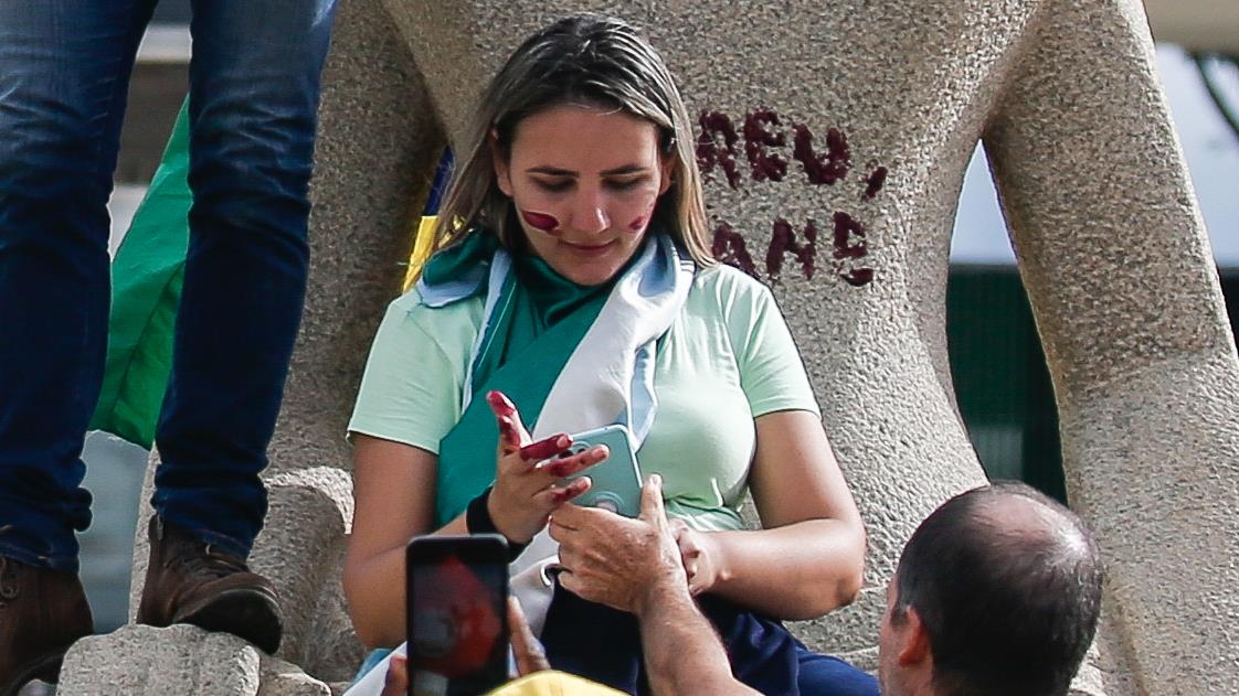 Débora Rodrigues dos Santos picha a estátua da Justiça, na praça dos Três Poderes, com a frase 