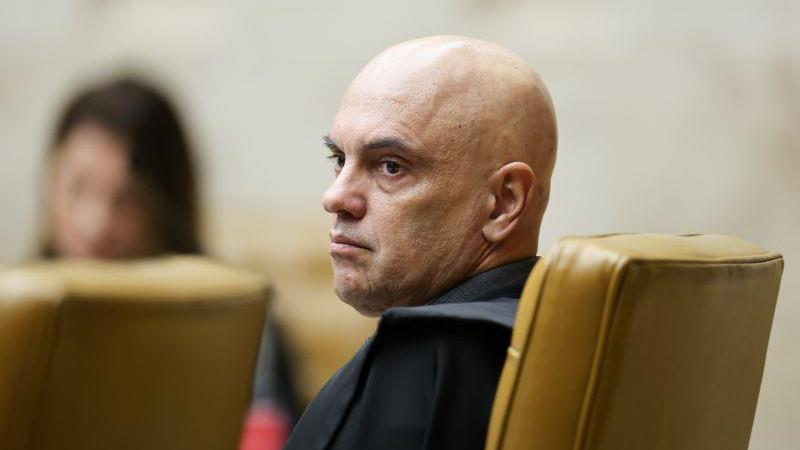 O ministro Alexandre de Moraes assina a decisão que autorizou a operação da PF contra Jair Bolsonaro.