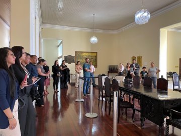 Imagem de estudantes prestando atenção ao servidor que apresenta a história do Tribunal