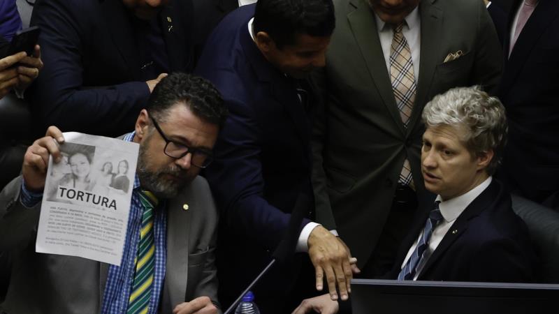 Marcos Pollon e Marcel Van Hatten ocupando cadeiras da Mesa Diretora da Câmara.