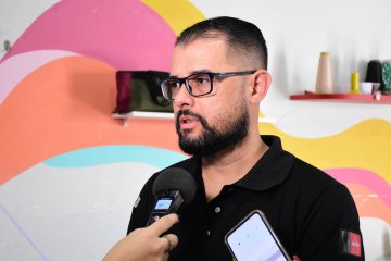 Na fotografia temos Sérgio Souza, diretor adjunto do Silvio Porto dando entrevista. ele veste uma camisa preta, usa óculos e tem barba