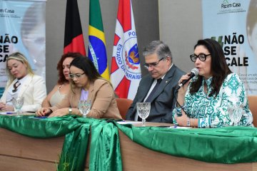 Foto da mesa dos trabalhos do evento, com a juíza Graziela